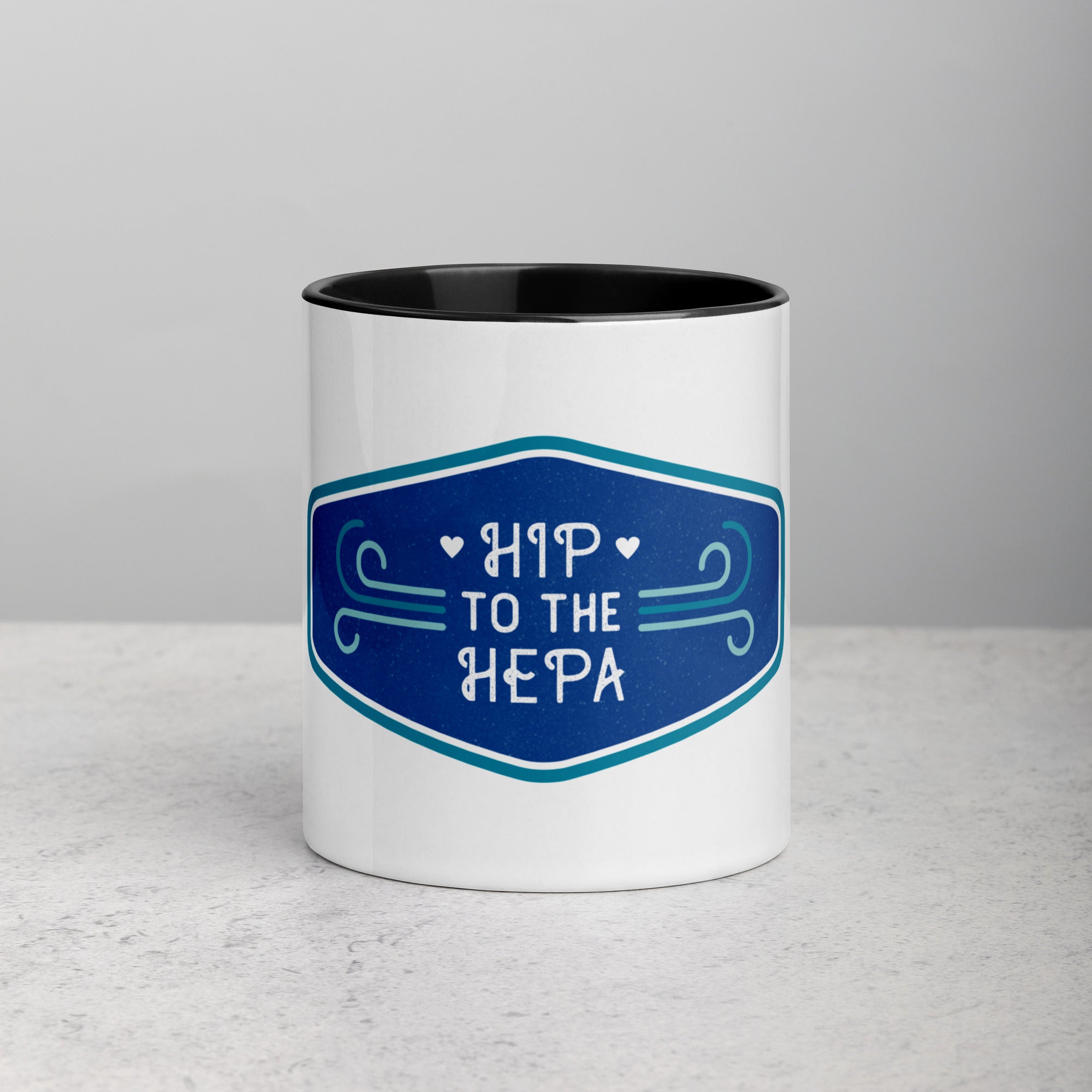 front facing white mug with black interior and handle. Mug has blue logo image with text 'hip to the hepa'